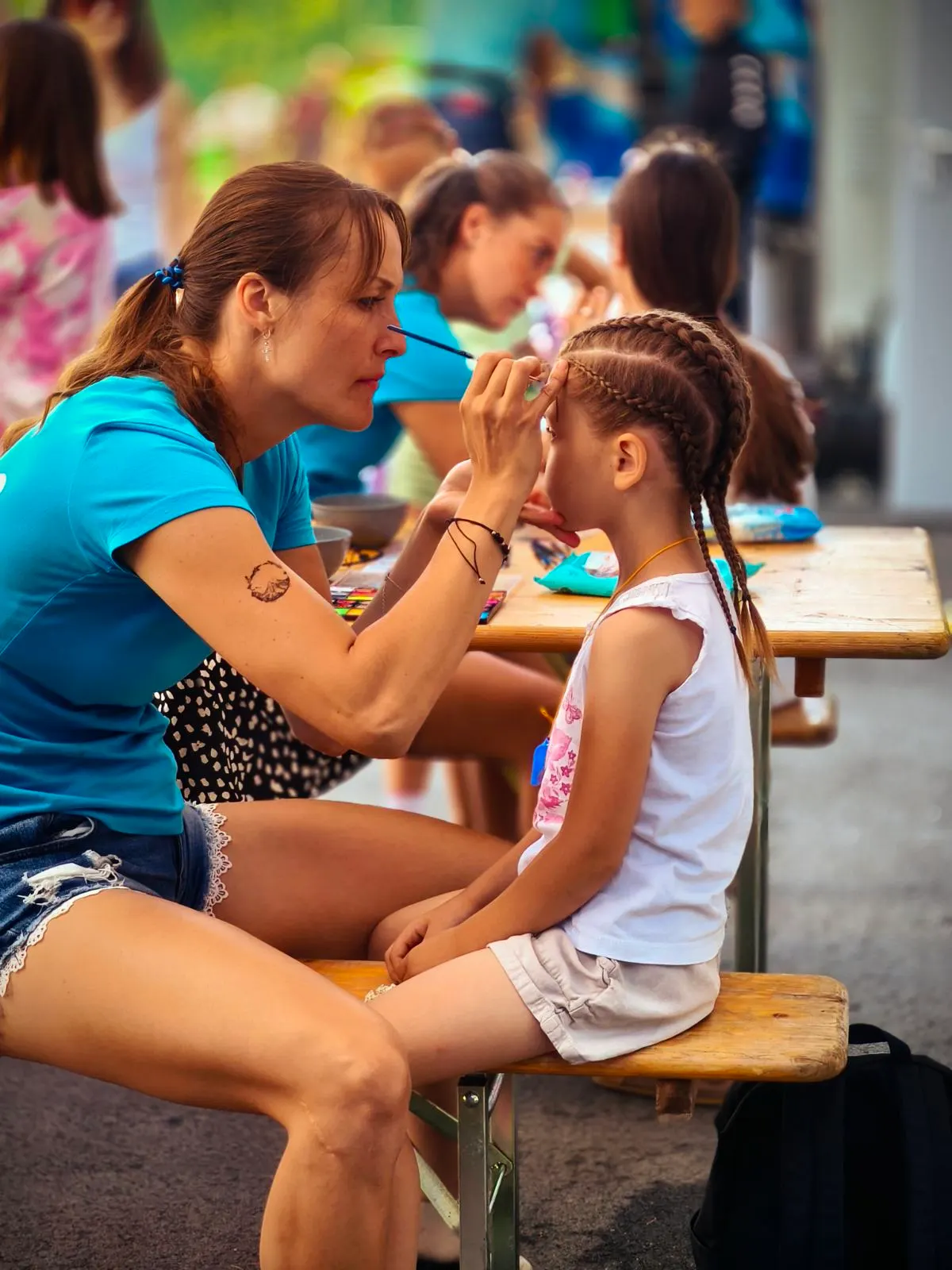 HepiKid animatorka izvaja poslikavo obraza otroka na terenu